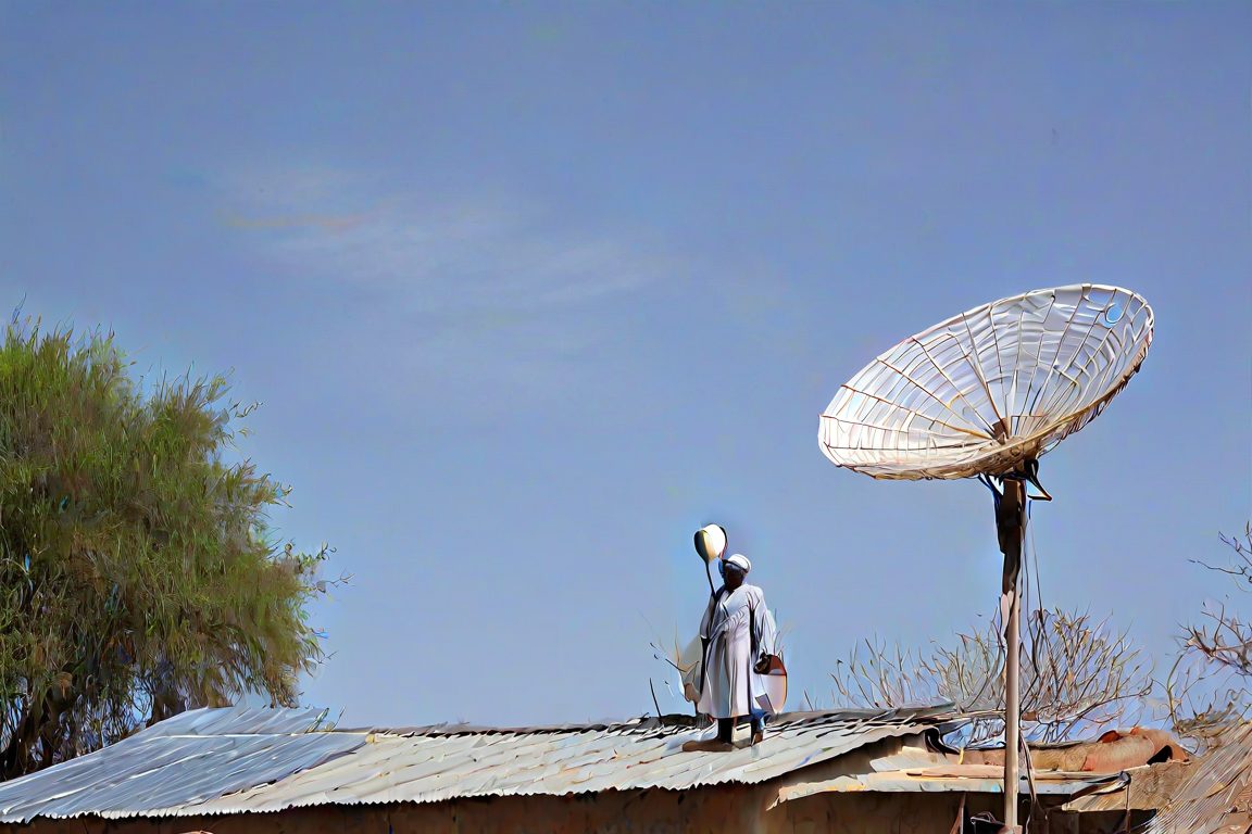 Technician installing a Starlink dish in a village